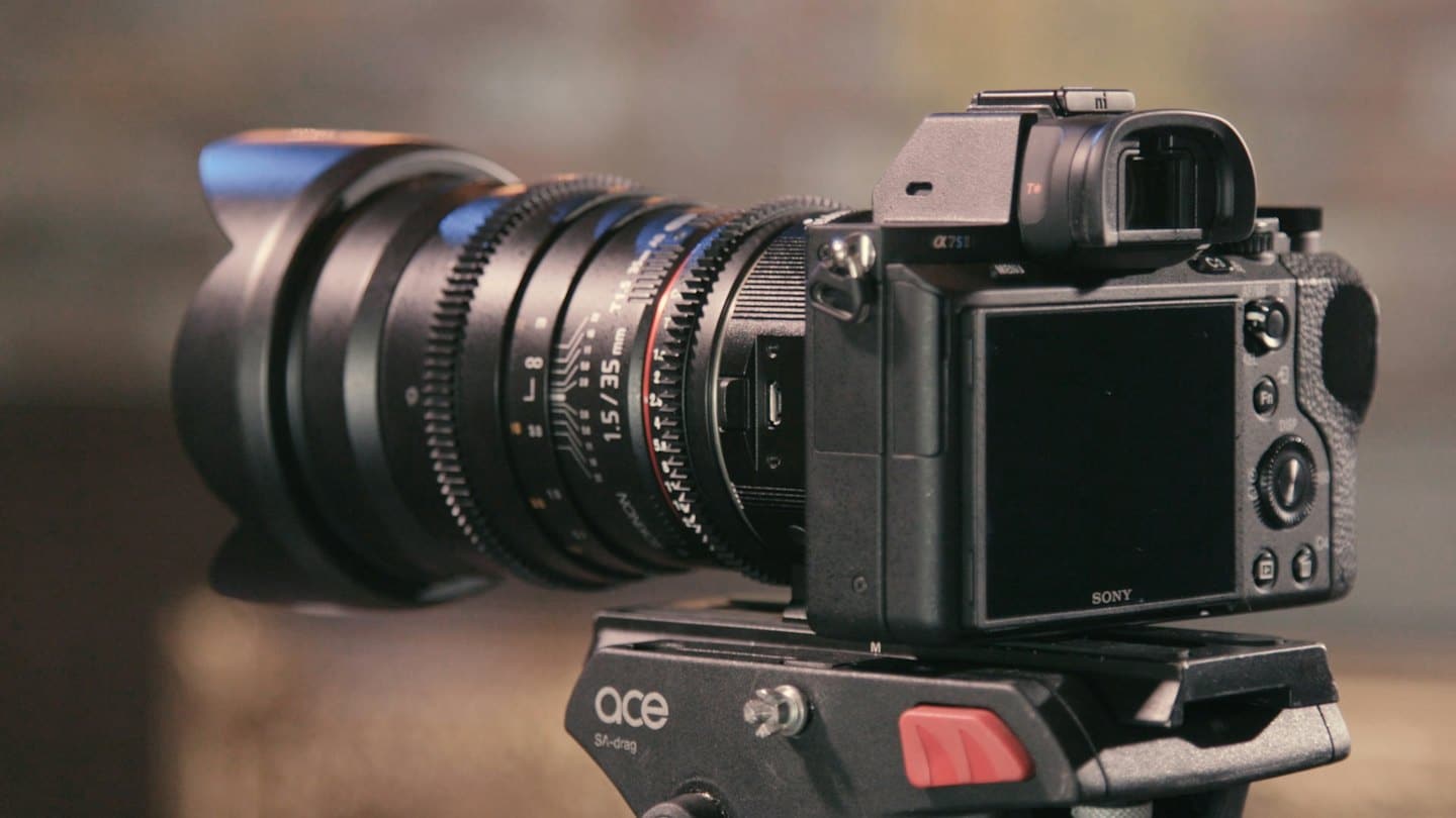 Macchina fotografica professionale con obiettivo cinematografico montata su treppiede.