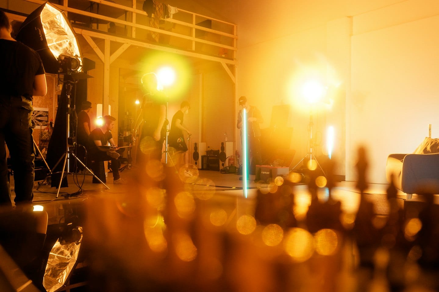 Membri di una troupe cinematografica allestiscono attrezzature professionali in uno studio.