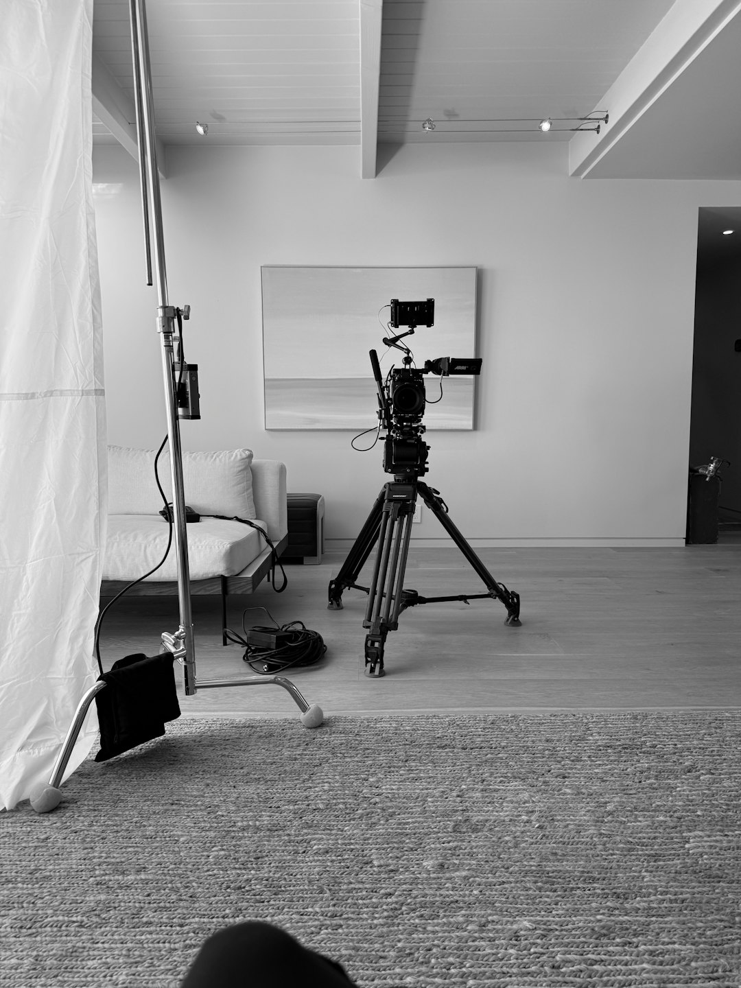 Attrezzatura per la produzione video allestita vicino a un divano.